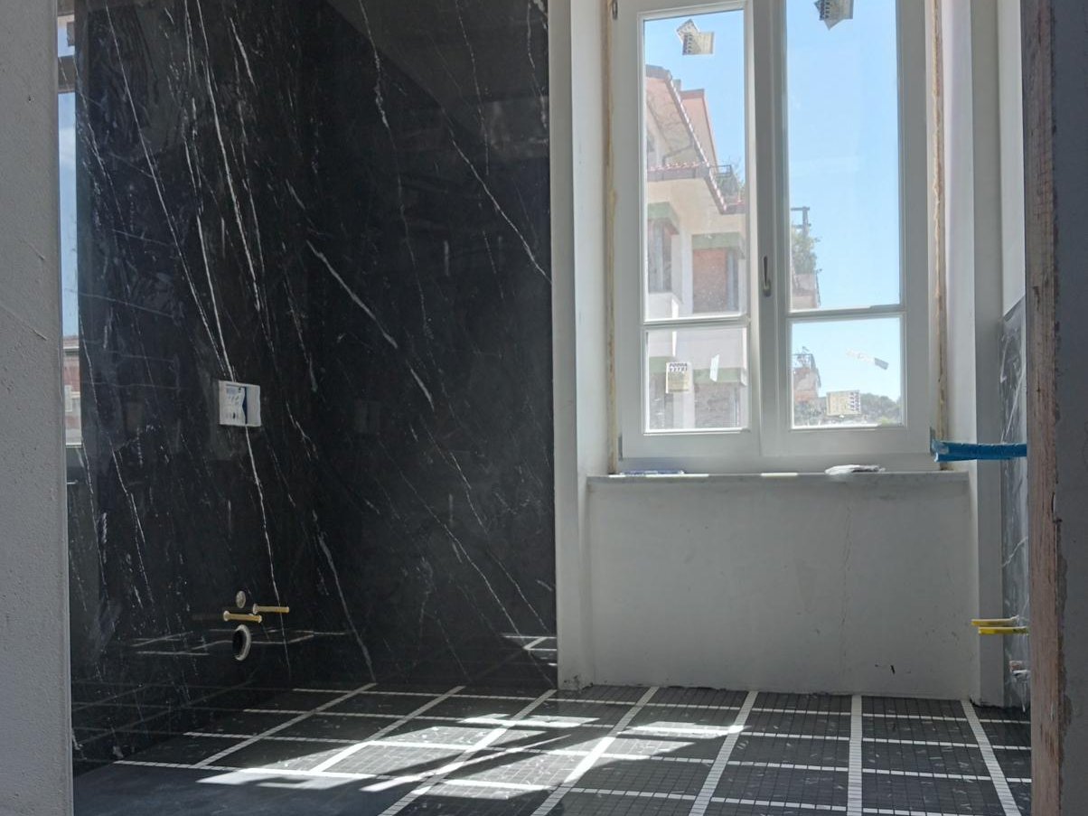 Cantiere di ristrutturazione a Cagliari con parete rivestita in lastre di marmo scuro